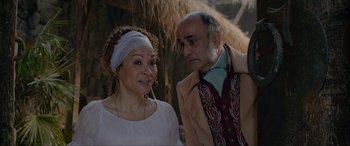 Movie still from “The Little Mermaid” (2023), directed by Rob Marshall – An older man standing next to an older woman; Close Up shot, Over the shoulder angle