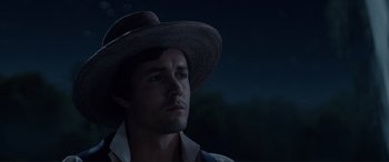 Movie still from “The Little Mermaid” (2023), directed by Rob Marshall – A man wearing a hat is looking into the distance; Close Up shot, Low angle