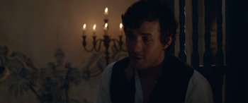 Movie still from “The Little Mermaid” (2023), directed by Rob Marshall – A man in front of a candle lit chandelier; Close Up shot, Over the shoulder angle