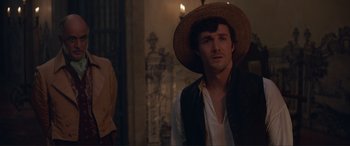 Movie still from “The Little Mermaid” (2023), directed by Rob Marshall – A man wearing a straw hat in a room; Medium shot, Over the shoulder angle