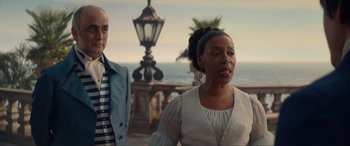Movie still from “The Little Mermaid” (2023), directed by Rob Marshall – A woman and a man standing next to each other near the ocean; Medium shot, Over the shoulder angle