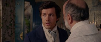 Movie still from “The Little Mermaid” (2023), directed by Rob Marshall – A person wearing a suit and tie; Close Up shot, Over the shoulder angle