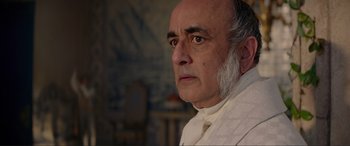 Movie still from “The Little Mermaid” (2023), directed by Rob Marshall – An older man wearing a white shirt and a white tie; Close Up shot, Over the shoulder angle