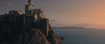 Movie still from “The Little Mermaid” (2023), directed by Rob Marshall – A castle on a cliff overlooking a body of water; Extreme Wide shot, Low angle