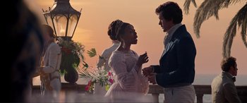 Movie still from “The Little Mermaid” (2023), directed by Rob Marshall – A man and a woman standing next to each other on a balcony; Medium shot, Over the shoulder angle