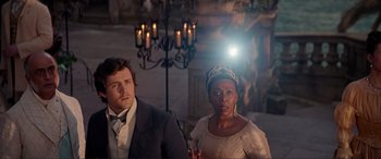 Movie still from “The Little Mermaid” (2023), directed by Rob Marshall – A man and a woman standing next to each other in front of candles; Medium shot, Over the shoulder angle