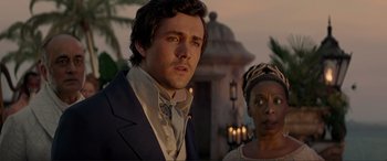 Movie still from “The Little Mermaid” (2023), directed by Rob Marshall – A man and a woman standing next to each other in front of a building; Close Up shot, Over the shoulder angle