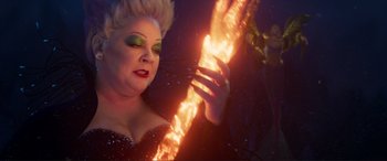 Movie still from “The Little Mermaid” (2023), directed by Rob Marshall – A drag queen with bright makeup and fire; Close Up shot, Overhead angle