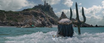 Movie still from “The Little Mermaid” (2023), directed by Rob Marshall – A view of a castle from the water of a boat; Extreme Wide shot, High angle