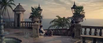 Movie still from “The Little Mermaid” (2023), directed by Rob Marshall – A man sitting on the ground next to a dog; Extreme Wide shot, High angle