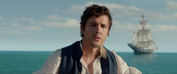 Movie still from “The Little Mermaid” (2023), directed by Rob Marshall – A person wearing a vest near a body of water; Close Up shot, Over the shoulder angle