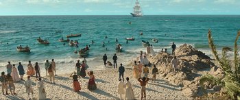 Movie still from “The Little Mermaid” (2023), directed by Rob Marshall – A group of people on a beach near the ocean; Extreme Wide shot, High angle
