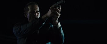 Movie still from “The Locksmith” (2023), directed by Nicolas Harvard – A man is holding a gun in the dark; Close Up shot, Low angle
