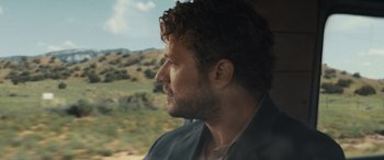 Movie still from “The Locksmith” (2023), directed by Nicolas Harvard – A person looking out of a car window; Close Up shot, Over the shoulder angle