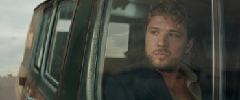 Movie still from “The Locksmith” (2023), directed by Nicolas Harvard – A person sitting in a car; Close Up shot, Over the shoulder angle