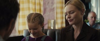 Movie still from “The Locksmith” (2023), directed by Nicolas Harvard – Two young girls sitting next to each other on a couch; Close Up shot, Over the shoulder angle