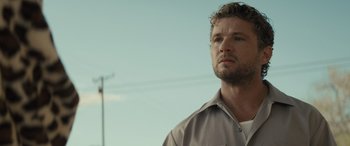 Movie still from “The Locksmith” (2023), directed by Nicolas Harvard – A person wearing a brown shirt; Close Up shot, Low angle