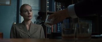 Movie still from “The Locksmith” (2023), directed by Nicolas Harvard – A woman sitting in front of a man in a room; Close Up shot, Over the shoulder angle