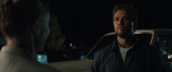 Movie still from “The Locksmith” (2023), directed by Nicolas Harvard – A person standing in a car at night; Close Up shot, Low angle