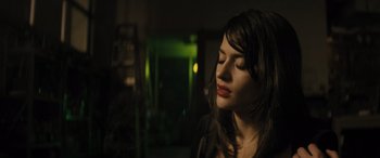 Movie still from “The Locksmith” (2023), directed by Nicolas Harvard – A beautiful woman with long dark brown hair and red lipstick; Close Up shot, Low angle