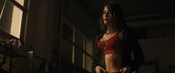 Movie still from “The Locksmith” (2023), directed by Nicolas Harvard – A beautiful young lady in a red bra and black jacket; Medium shot, Low angle