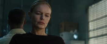 Movie still from “The Locksmith” (2023), directed by Nicolas Harvard – A person wearing a black shirt; Close Up shot, Over the shoulder angle