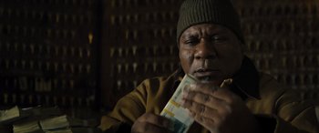 Movie still from “The Locksmith” (2023), directed by Nicolas Harvard – A man is holding money in his hands; Close Up shot, Low angle