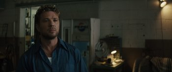Movie still from “The Locksmith” (2023), directed by Nicolas Harvard – A man standing in front of an empty garage; Close Up shot, Over the shoulder angle