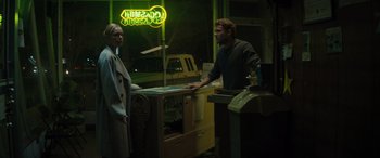 Movie still from “The Locksmith” (2023), directed by Nicolas Harvard – A man and a woman standing in front of a store window; Medium shot, Over the shoulder angle
