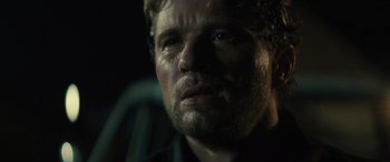 Movie still from “The Locksmith” (2023), directed by Nicolas Harvard – A person with a beard; Close Up shot, Over the shoulder angle