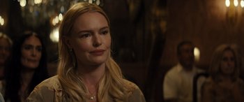 Movie still from “The Locksmith” (2023), directed by Nicolas Harvard – A woman with blonde hair is looking to her left; Close Up shot, Over the shoulder angle