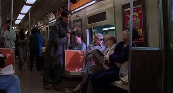 Movie still from “The Lost World: Jurassic Park” (1997), directed by Steven Spielberg – A group of people sitting on a subway train; Wide shot, High angle