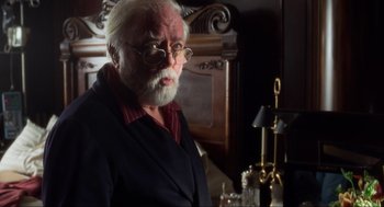 Movie still from “The Lost World: Jurassic Park” (1997), directed by Steven Spielberg – An older man with a beard and glasses; Medium shot, Over the shoulder angle