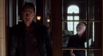 Movie still from “The Lost World: Jurassic Park” (1997), directed by Steven Spielberg – A man standing in front of a mirror in front of a window; Medium shot, Over the shoulder angle