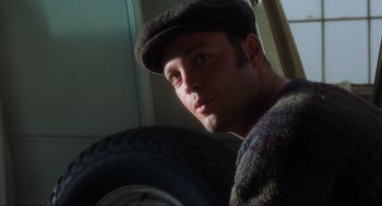 Movie still from “The Lost World: Jurassic Park” (1997), directed by Steven Spielberg – A man wearing a hat and holding a tire; Close Up shot, Low angle