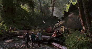 Movie still from “The Lost World: Jurassic Park” (1997), directed by Steven Spielberg – A group of people walking through a forest; Extreme Wide shot, Over the shoulder angle