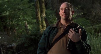 Movie still from “The Lost World: Jurassic Park” (1997), directed by Steven Spielberg – A man holding a camera in the woods; Medium shot, Low angle