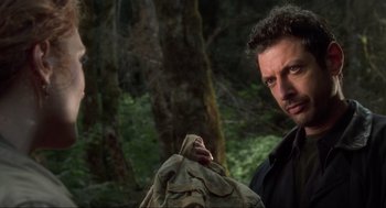 Movie still from “The Lost World: Jurassic Park” (1997), directed by Steven Spielberg – A man in a black shirt is holding something in his hand; Close Up shot, Over the shoulder angle