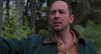 Movie still from “The Lost World: Jurassic Park” (1997), directed by Steven Spielberg – A man with a bald head is standing in the woods; Close Up shot, Low angle