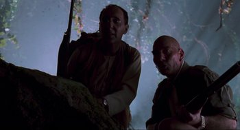 Two men are sitting next to each other in the dark