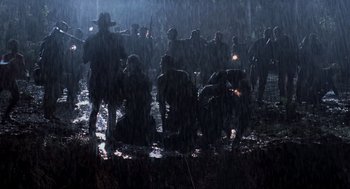 Movie still from “The Lost World: Jurassic Park” (1997), directed by Steven Spielberg – A group of people standing in the rain under a tree; Wide shot, High angle