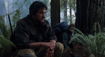 Movie still from “The Lost World: Jurassic Park” (1997), directed by Steven Spielberg – A man sitting on the ground in the woods; Medium shot, Low angle