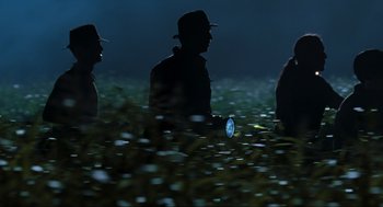 Movie still from “The Lost World: Jurassic Park” (1997), directed by Steven Spielberg – A group of people in a field at night with a flashlight; Wide shot, High angle