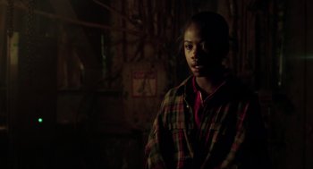 Movie still from “The Lost World: Jurassic Park” (1997), directed by Steven Spielberg – A man in a plaid shirt is standing in the dark; Close Up shot, Over the shoulder angle