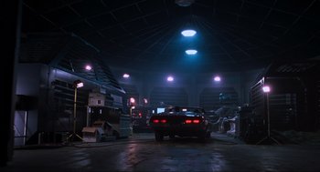 Movie still from “The Lost World: Jurassic Park” (1997), directed by Steven Spielberg – A car parked inside of a building at night time; Wide shot, Low angle