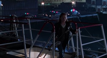 Movie still from “The Lost World: Jurassic Park” (1997), directed by Steven Spielberg – A woman standing on a railing in a parking lot at night; Wide shot, Low angle