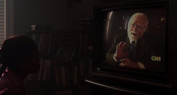 Movie still from “The Lost World: Jurassic Park” (1997), directed by Steven Spielberg – An old man is sitting in front of a television; Medium shot, High angle