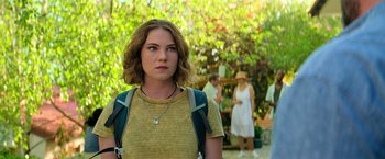 Movie still from “The Machine” (2023), directed by Peter Atencio – A woman with a backpack standing in front of a tree; Close Up shot, Over the shoulder angle