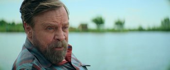 Movie still from “The Machine” (2023), directed by Peter Atencio – A person with a beard; Close Up shot, Over the shoulder angle