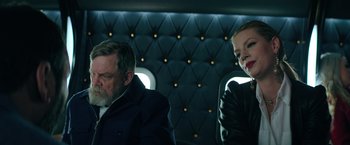 Movie still from “The Machine” (2023), directed by Peter Atencio – A man and a woman sitting in a car; Medium shot, Low angle